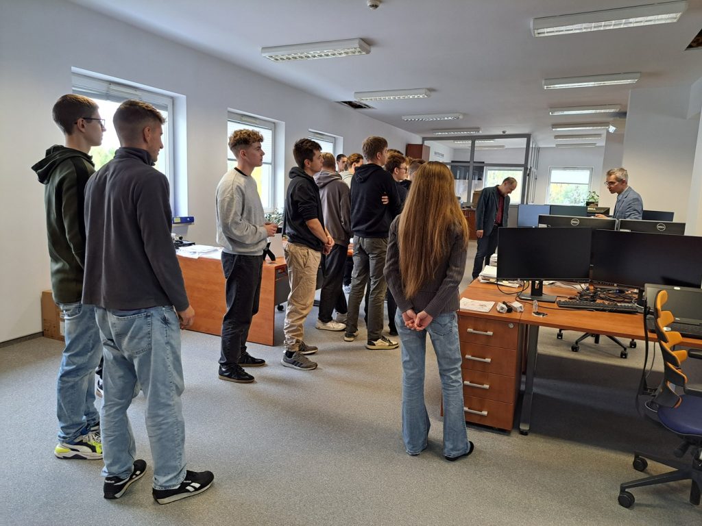 Studenci w Biurze Projektowym APS słuchają jak przebiega proces realizacji projektów od projektowania po wdrożenie