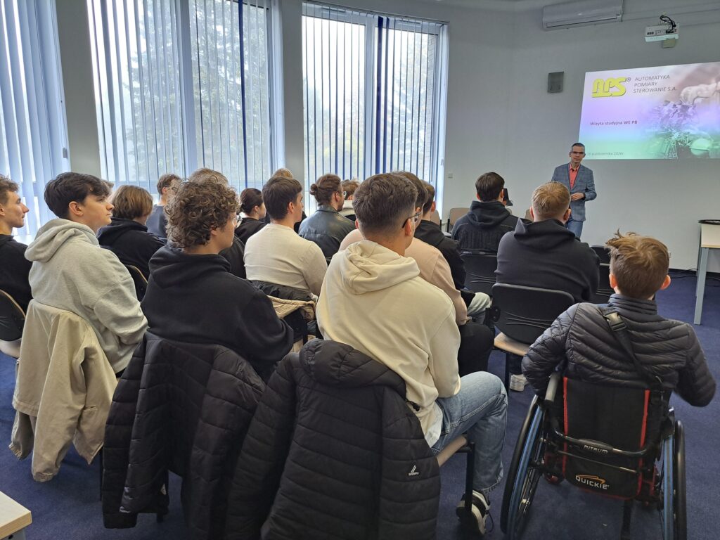 Studenci Wydziału Elektrycznego Politechniki Białostockiej podczas wizyty studyjnej w APS S.A. Uczestnicy spotkania słuchają prezentacji dotyczącej działalności firmy.